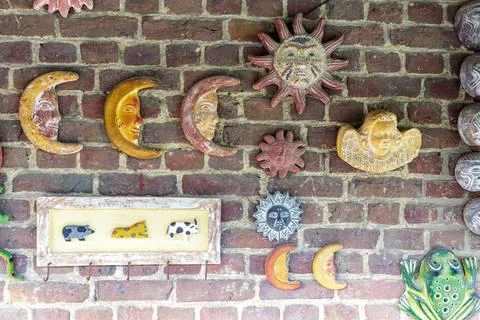 Multiple decorative figures on exterior brick wall worn down by time Stock Photos