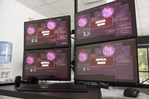 Multiple desktop monitors in empty office display critical system error messages 스톡 사진