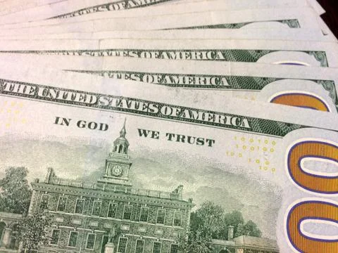 Multiple dollar bills reading In God We Trust Stock Photos