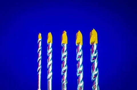 Multiple drill bits on solid blue background symbolizing diy tools and craf.. Stock Photos