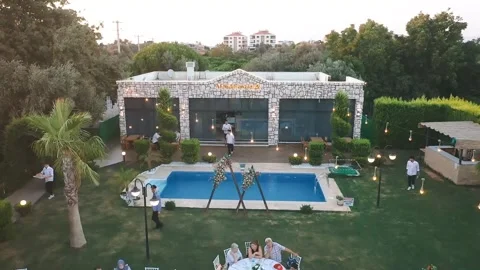 Multiple drone footage of guests attending a wedding hall accompanied by sunset Stock Footage 255717118