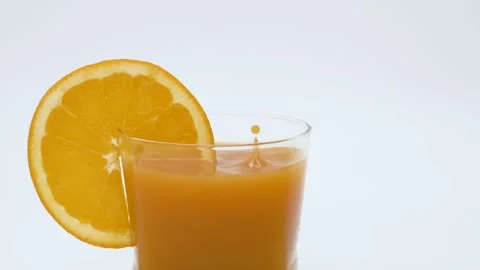 Multiple drops of juice dropping in a glass with orange juice - slow motion Video stock 145813797