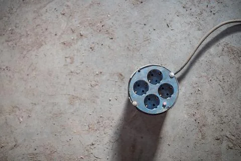 Multiple electrical sockets with four outlets isolated on the grey concrete Stock Photos