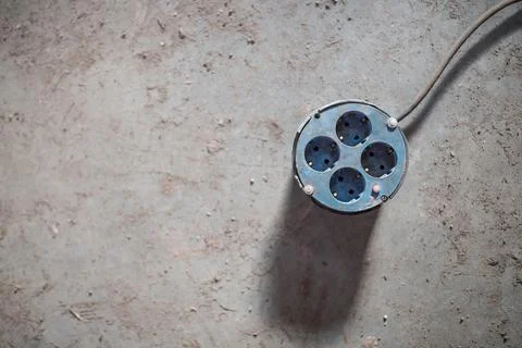 Multiple electrical sockets with four outlets isolated on the grey concrete Stock Photos