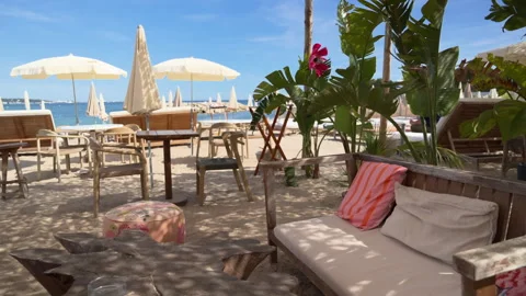 Multiple empty beach lounge and seating area scenes with tropical plants and Stock Footage 336976106