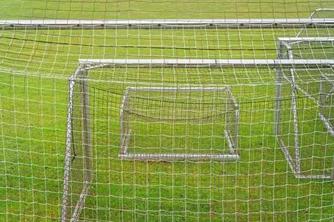 Multiple empty soccer goals on green grass field with white nets in daylight Stock Photos