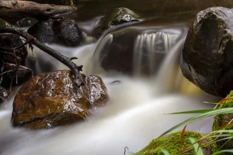 Multiple exposure of the cold stream of a ravine in the mountains near the co Stock Photos