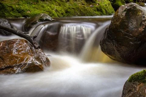 Multiple exposure of the cold stream of a ravine in the mountains near the co Stock Photos