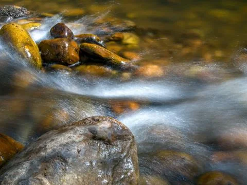 Multiple exposure of the cold stream of a ravine in the mountains near the co Stock Photos