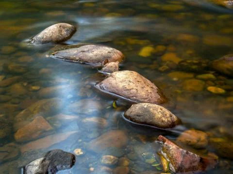 Multiple exposure of the cold stream of a ravine in the mountains near the co Stock Photos