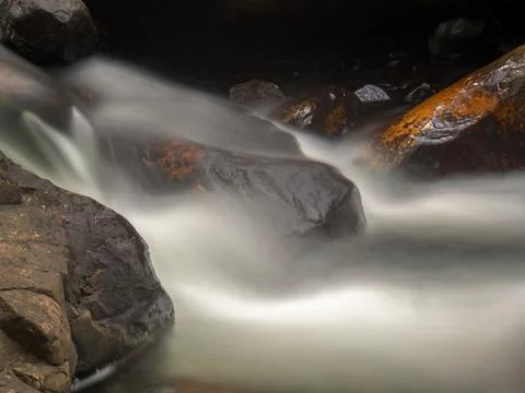 Multiple exposure of the cold stream of a ravine in the mountains near the co Stock Photos