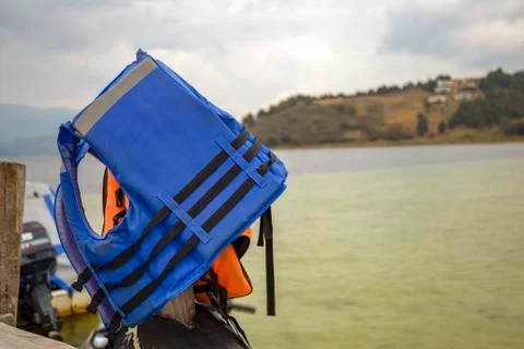 Multiple exposure of lifejackets hanging from one of the posts of the wooden  Stock Photos