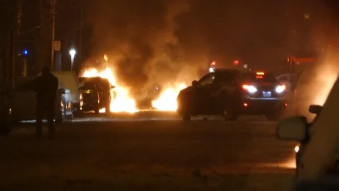 Multiple fires burning in dark street during scene of disarray after BLM riots Stock Footage