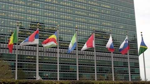 Multiple flags in front of the United Nations headquarters in New York City Stock Footage