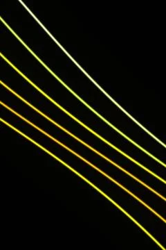 Multiple glowing yellow, lime, and pale green lines travel diagonally over .. Stock Illustration