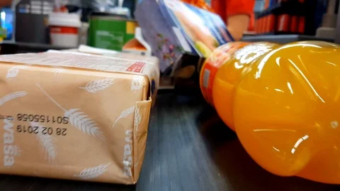Multiple groceries placed on a moving conveyor belt checkout, seen from Stock Footage 92594681