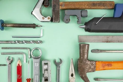 Multiple hand tools arranged on green background, with empty square copy sp.. Stock Photos