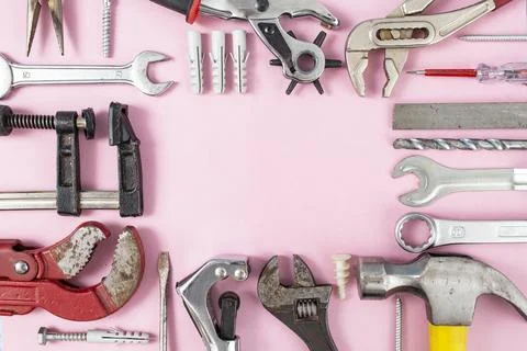 Multiple hand tools arranged on green background, with empty triangular sha.. Stock Photos