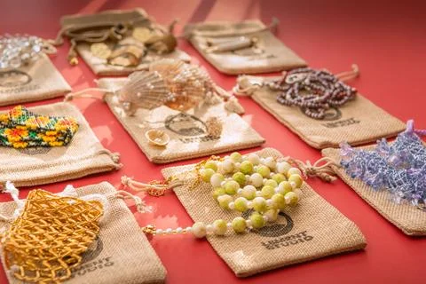 Multiple handmade jewelries on custom made bags on magenta red background Stock Photos