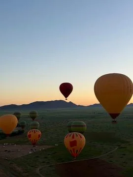 Multiple Hot Air Balloons Flying over the Desert Landscape near Marrakech Stock Photos