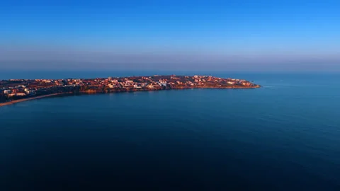 Multiple houses located on the spit surrounded by the beautiful dark blue Stock Footage 321308461