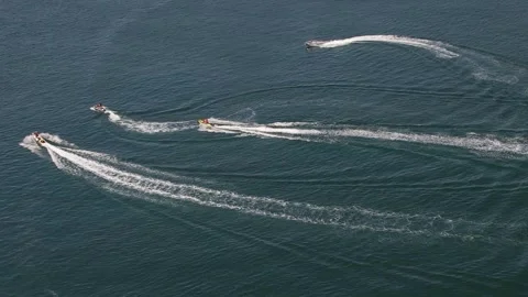 Multiple jet skis converging in the water - Aerial footage Stock Footage 247445663