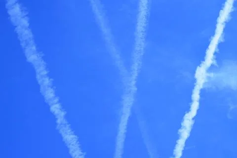 Multiple jet streams of aiplane on blue skiy.. Stock Photos
