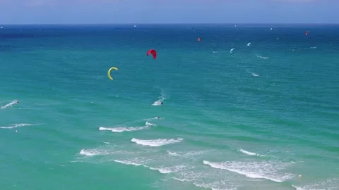 Multiple kite surfers enjoying weather of beautiful shade of turquoise ocean Stock Footage 264522005