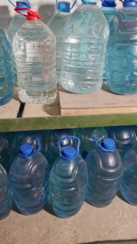 Multiple Large Plastic Water Bottles Stored on Shelves in a Dark Room Stock Footage 335646935