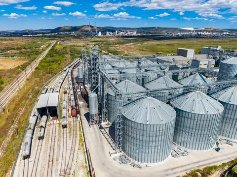 Multiple large storage silos next to train tracks in an open agricultural are Foto stock