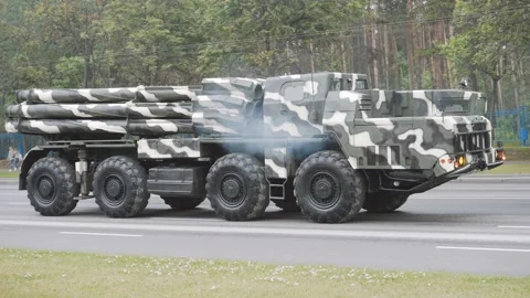 Multiple launch rocket system Smerch accelerates on green street with exhaust. Stock Footage 171589314