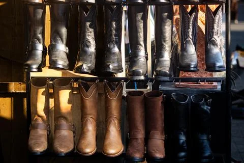 Multiple Leather Biker and Cowboy Boots displayed on rack shelf Stock Photos