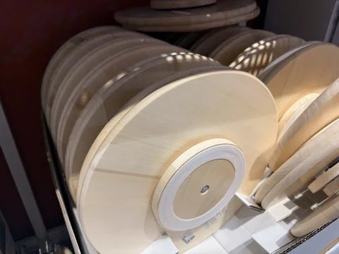 Multiple light wood round bases stacked in a retail setting with natural ligh Stock Photos