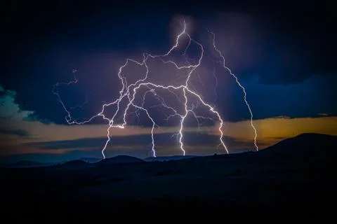 Multiple lightning strikes on distant mountain Stock Photos