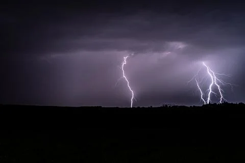 Multiple lightning strikes lighting up the sky on a summer evening during a.. Stock Photos