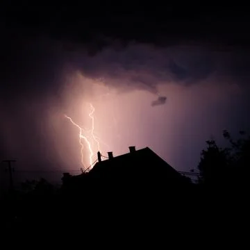 Multiple lightning strikes painting the sky purple on a summer evening duri.. Stock Photos