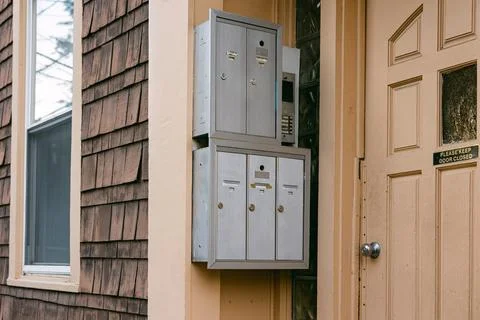 Multiple mailboxes attached to a residential building entrance with a doorbell Foto stock