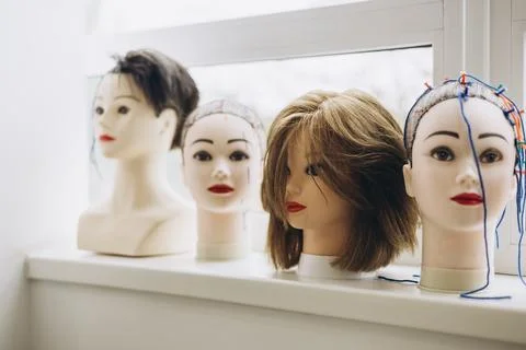 Multiple mannequin heads used for practicing haircuts and hairstyles. Stock Photos