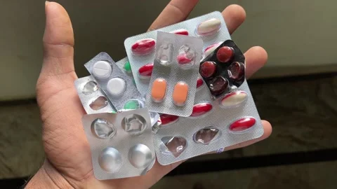 Multiple Medicine Tablet Strips Held in Hand Close Up Stock Footage 320285568