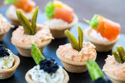 Multiple mini pastry tartlets with seafood filling. Stock Photos
