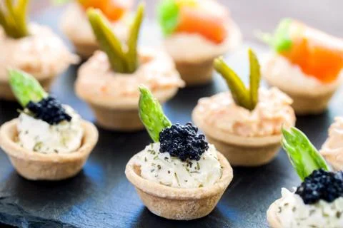 Multiple mini puff pastry tartlets with savory filling. Foto stock