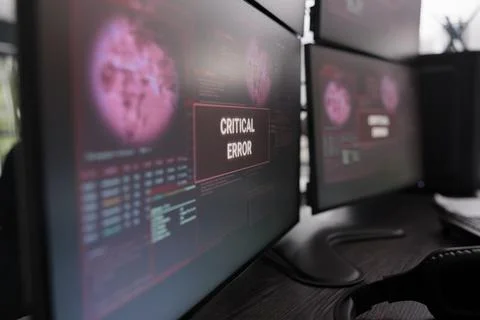 Multiple monitors showing critical error message after cyber crime attack Stockfoto's