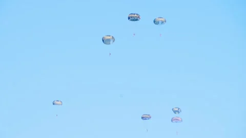 Multiple nato parachutist descending in formation against a clear blue sky Stock Footage 286335686
