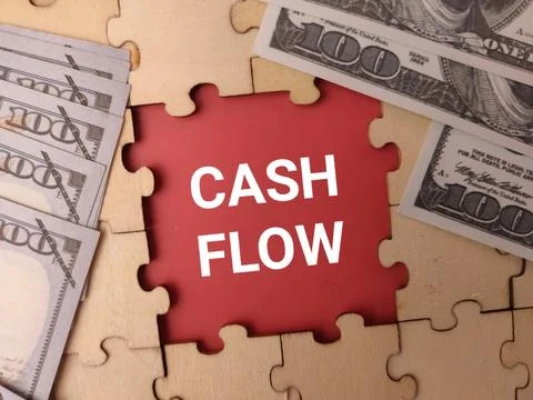 Multiple one-hundred dollar bills frame a red opening in a jigsaw puzzle co.. 库存照片