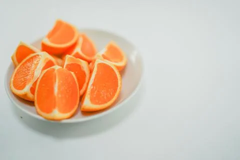 Multiple oranges placed on a white plate Photos