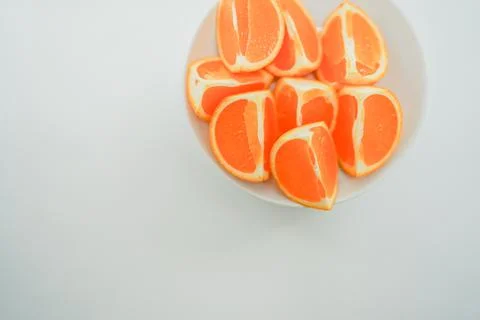 Multiple oranges placed on a white plate Photos