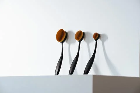 Multiple oval makeup face brushes on white background Stock Photos