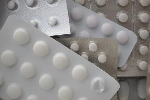 Multiple packs of white tablets on a flat surface Stock Photos