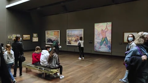 Multiple paintings and tourists inside a gallery of the Orsay museum in Stock Footage 161945271