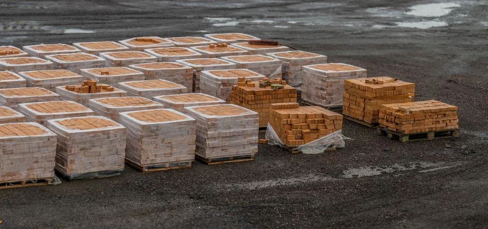 Multiple pallets of teal bricks at a building site. Fotos de archivo